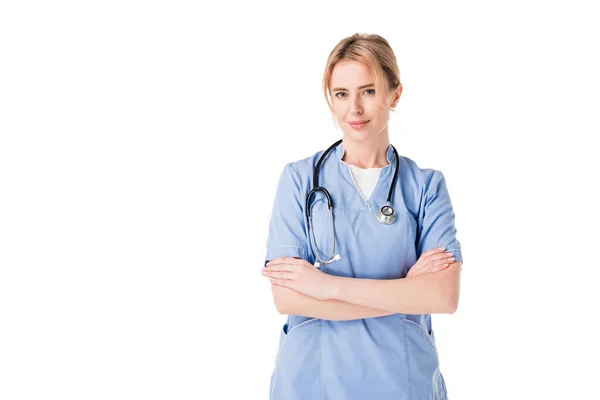 Female nurse in uniform with stethoscopes standing with arms folded isolated on white — Stock Photo