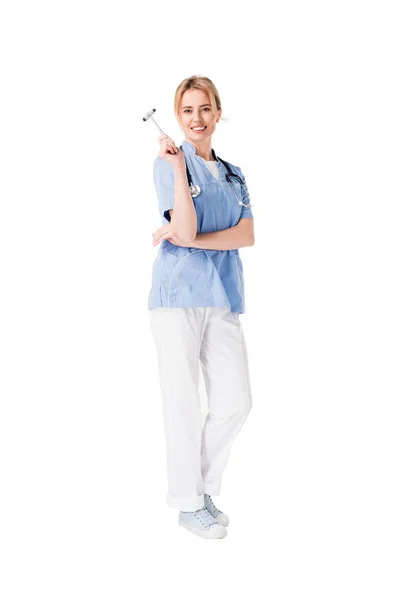 Jovem enfermeira sorridente de uniforme com martelo reflexo isolado em branco — Fotografia de Stock