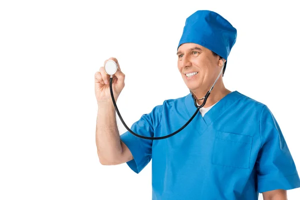 Médico masculino sorridente de uniforme usando estetoscópio isolado em branco — Fotografia de Stock