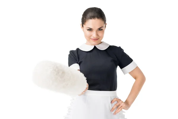 Brunette maid in professional uniform holding duster isolated on white — Stock Photo