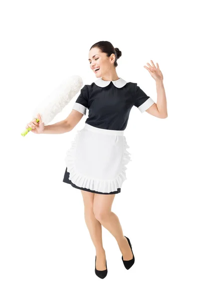 Professional maid in uniform having fun and singing in duster isolated on white — Stock Photo