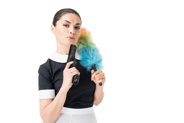 Professional maid in uniform holding duster and gun isolated on white — Stock Photo