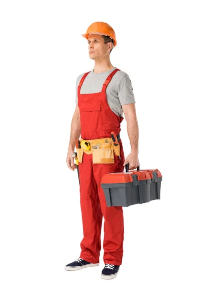 Handsome builder in uniform with tool belt holding toolbox isolated on white — Stock Photo