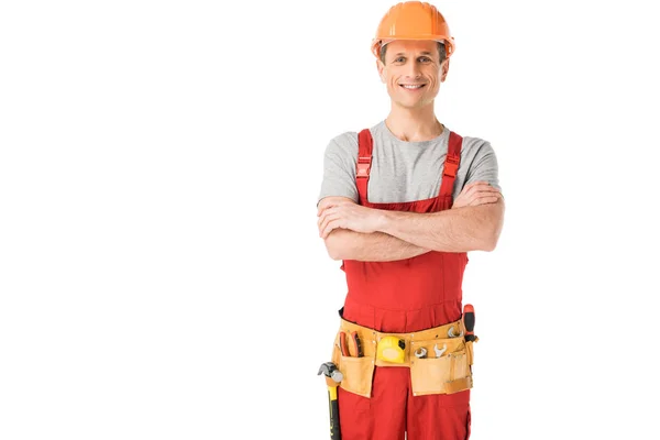 Alegre trabajador de la construcción en uniforme con los brazos cruzados aislados en blanco - foto de stock