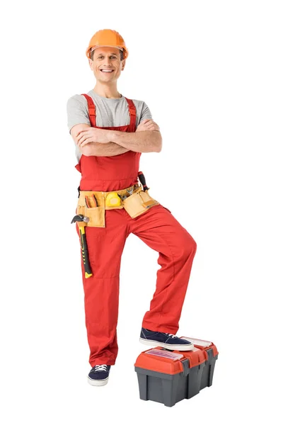 Builder with tools in belt standing with folded arms isolated on white — Stock Photo