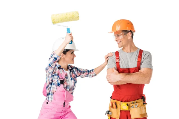 Constructores masculinos y femeninos jugando con rodillo de pintura aislado en blanco — Stock Photo