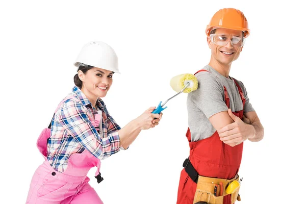 Woman construction worker painting man with paint roller isolated on white — Stock Photo