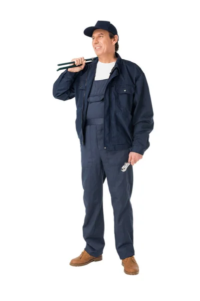 Fontanero profesional en overoles con llaves aisladas en blanco - foto de stock