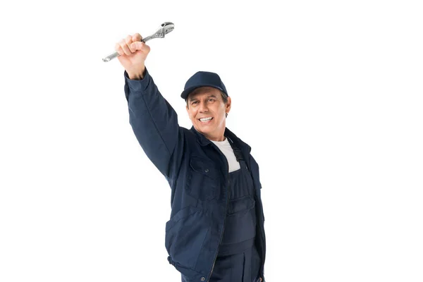 Handsome plumber in uniform holding adjustable wrench isolated on white — Stock Photo