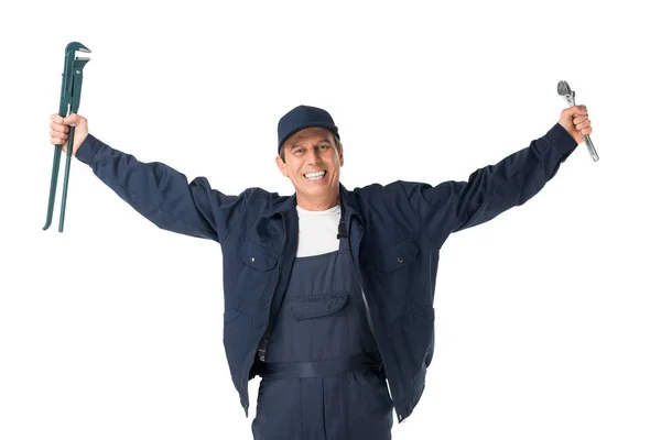 Lächelnder Handwerker in Overalls, der verstellbare Schraubenschlüssel isoliert auf weiß hält — Stockfoto