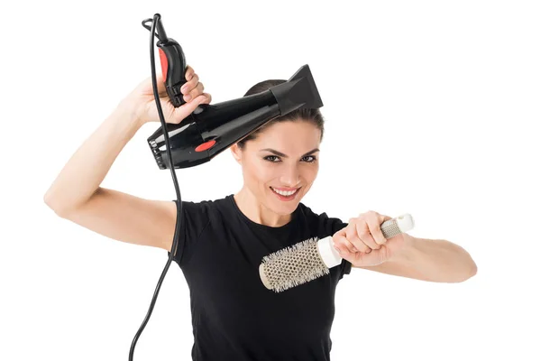 Peluquería femenina sonriente con secador y cepillo aislado en blanco - foto de stock