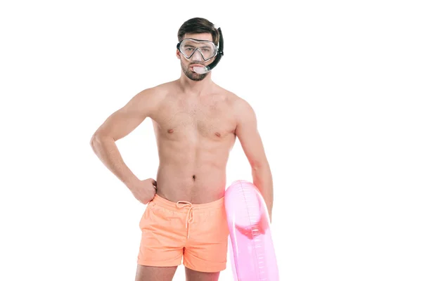 Handsome young man in diving mask and snorkel holding inflatable ring and looking at camera isolated on white — Stock Photo