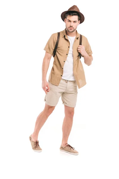 Vue pleine longueur de beau jeune voyageur avec sac à dos regardant la caméra isolée sur blanc — Photo de stock