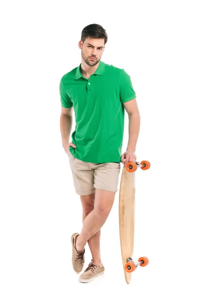 Stylish young man leaning at skateboard and looking at camera isolated on white — Stock Photo