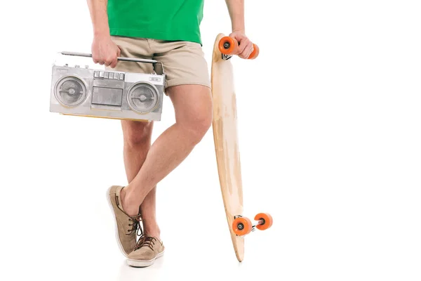 Cropped shot of young man in shorts holding skateboard and tape recorder isolated on white — Stock Photo