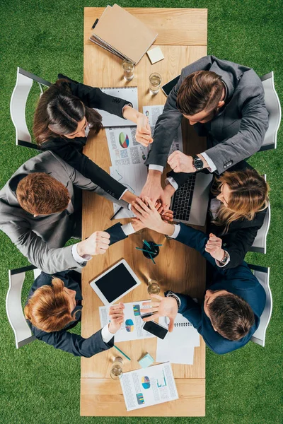 Верхний взгляд на бизнес-партнеров за столом в офисе, деловые круги — стоковое фото