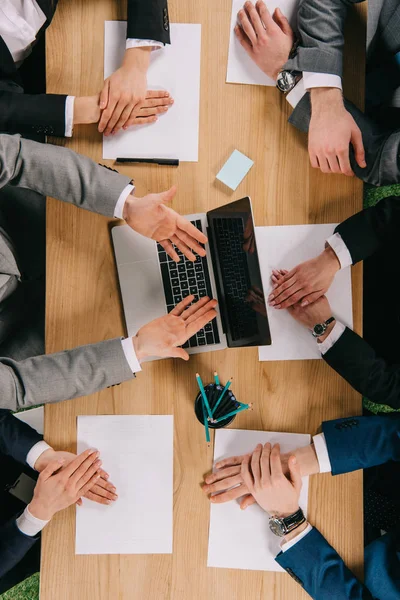 Imagem cortada de empresário mostrando apresentação a parceiros à mesa no escritório — Fotografia de Stock