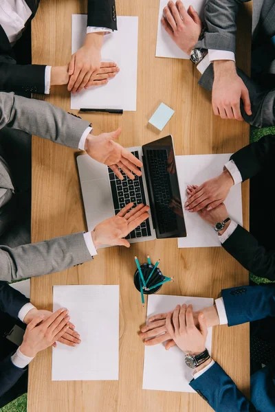 Abgeschnittenes Bild eines Geschäftsmannes, der Partnern am Tisch im Büro seine Präsentation zeigt — Stockfoto