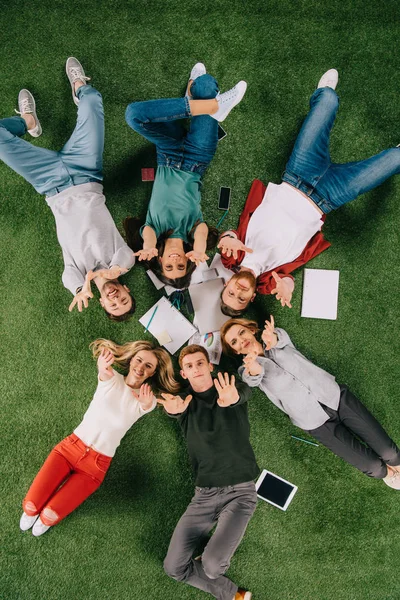 Vue aérienne des gens d'affaires heureux avec les bras levés sur l'herbe — Photo de stock