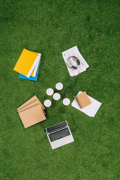 Vista dall'alto di oggetti aziendali e forniture per ufficio posa su tappeto di erba verde — Foto stock