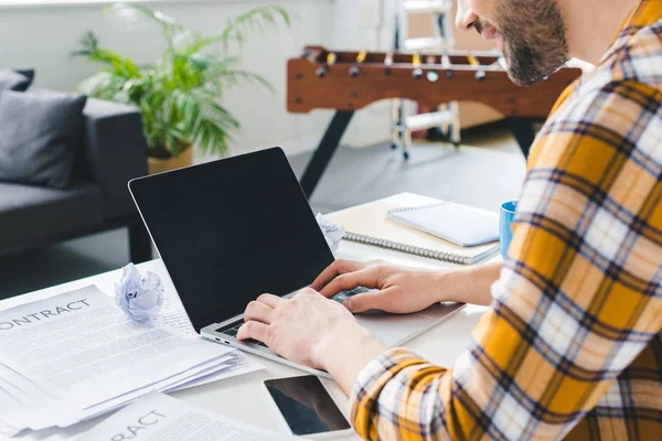 Close-up view of man typing on laptop keyboard at home office — Stock Photo