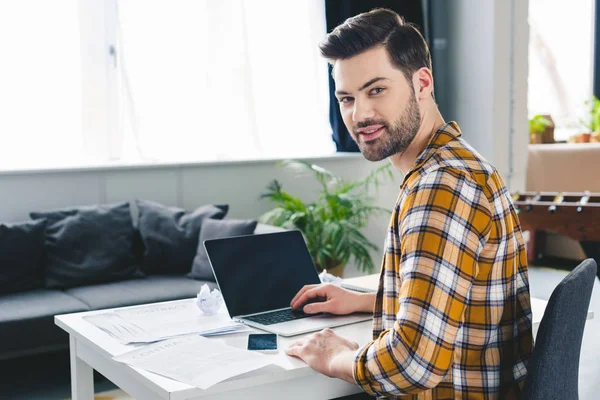 Jeune homme d'affaires travaillant par ordinateur portable dans un bureau léger — Photo de stock