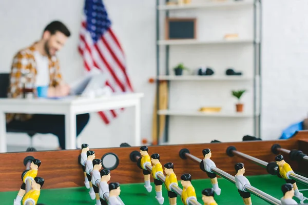 Close-up view of foosball in front of businessman working in light office — Stock Photo