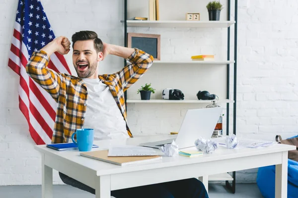 Müder Geschäftsmann dehnt sich am Arbeitstisch im Home Office — Stockfoto