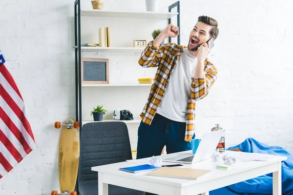 Riendo hombre hablando por teléfono en la oficina en casa - foto de stock