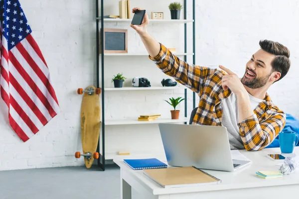 Smiling man taking selfie at home office — Stock Photo