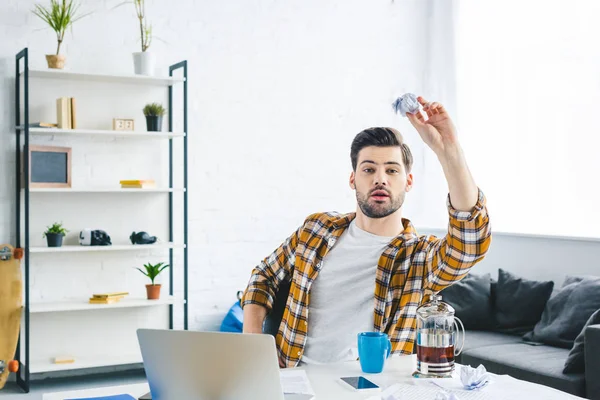 Mann wirft zerknülltes Papier während der Arbeit im Home Office — Stockfoto