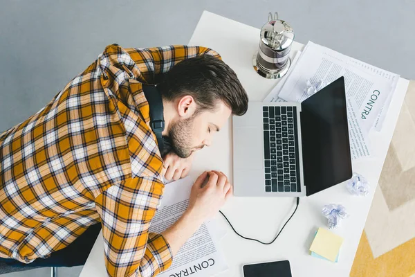 Uomo che dorme sul tavolo con computer portatile a casa ufficio — Foto stock