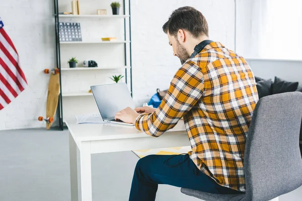 Empresario escribiendo en el teclado del ordenador portátil en la oficina en casa - foto de stock