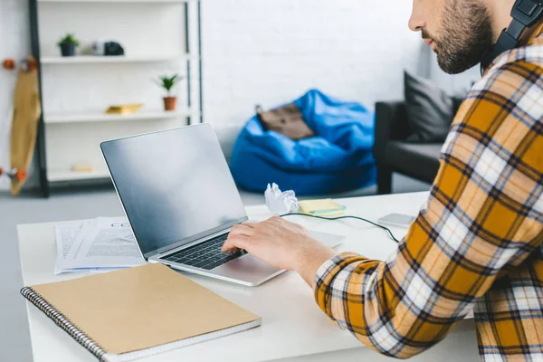 Young man looking at laptop screen in light office — Stock Photo