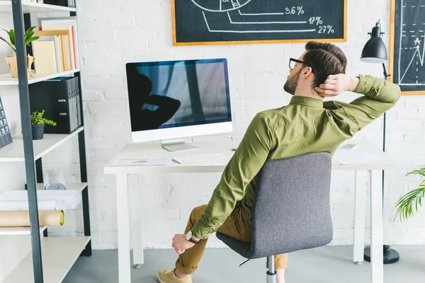 Freelancer cansado alongamento por mesa de trabalho em escritório leve — Fotografia de Stock