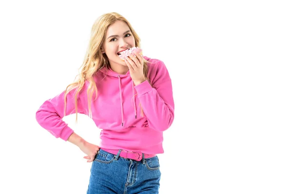 Attraente ragazza vestita con ciambella rosa mordente isolata su bianco — Foto stock