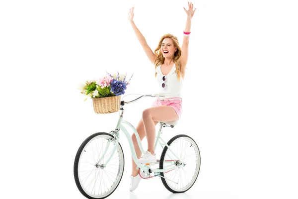 Mulher loira andando de bicicleta com flores em cesta isolada em branco — Fotografia de Stock
