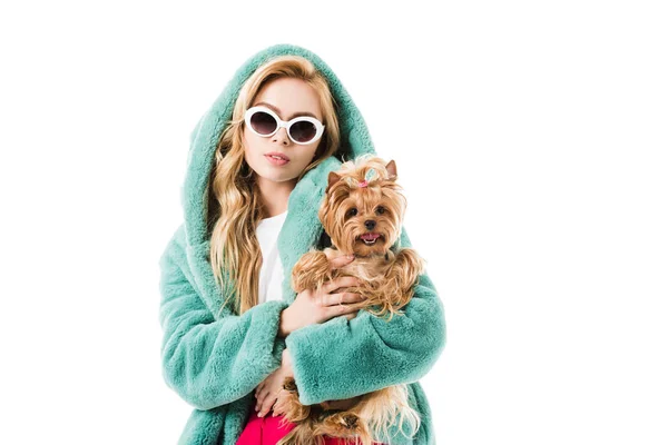 Blonde woman in fir coat hugging Yorkshire terrier isolated on white — Stock Photo