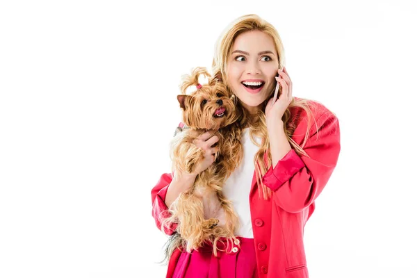 Junges Mädchen in pinkfarbener Jacke hält einen York Terrier in der Hand und telefoniert isoliert auf weiß — Stockfoto