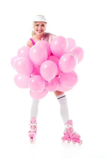 Young girl in roller skates holding pink balloons isolated on white — Stock Photo