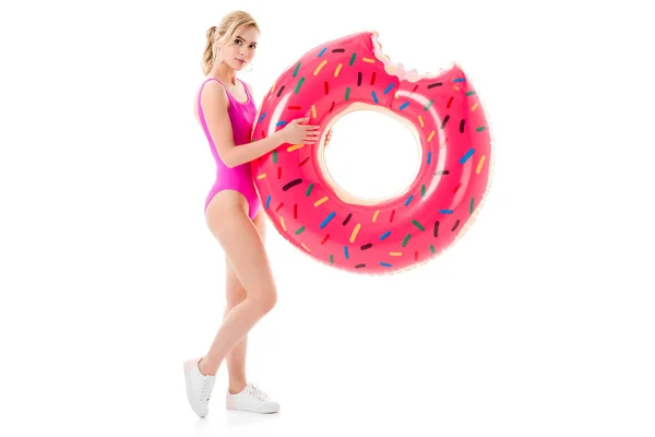 Young girl wearing pink swimsuit holding doughnut swim ring isolated on white — Stock Photo