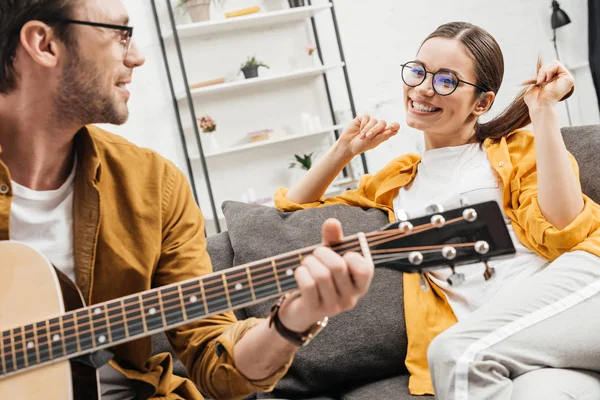 Junger Mann spielt Gitarre für glückliche Freundin — Stockfoto