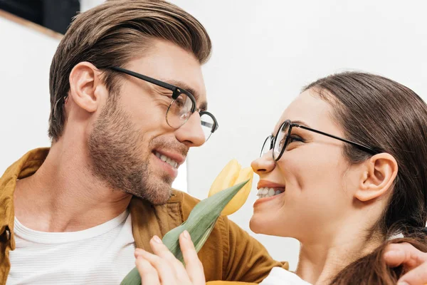 Close-up shot of happy young man presenting tulip flower to girlfriend — Stock Photo