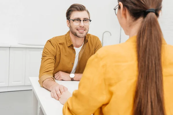 Happy loving couple sitting on kitchen together and chatting — Stock Photo