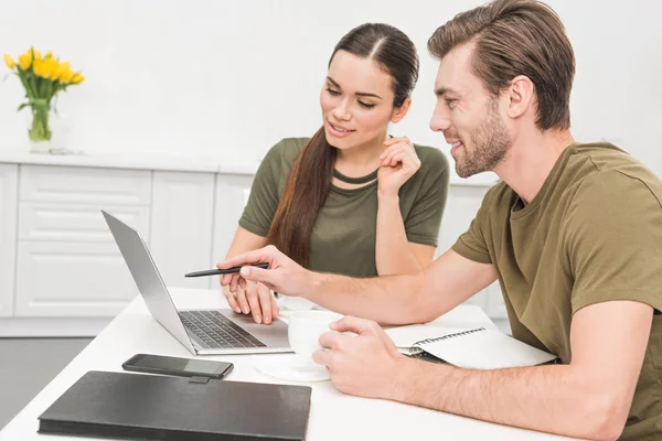 Atractiva pareja joven trabajando juntos en casa - foto de stock