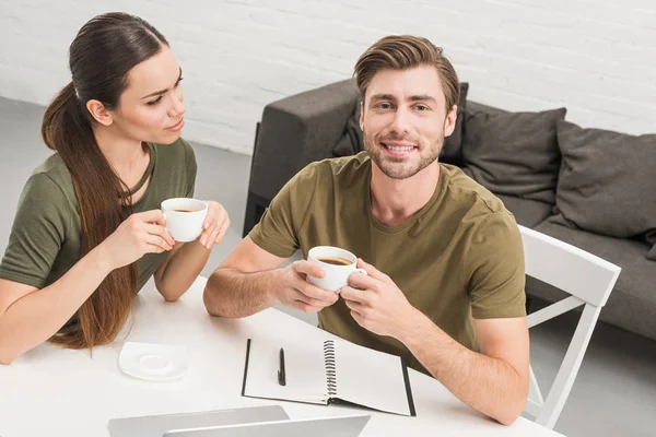 Jovem casal feliz beber café juntos em casa — Fotografia de Stock