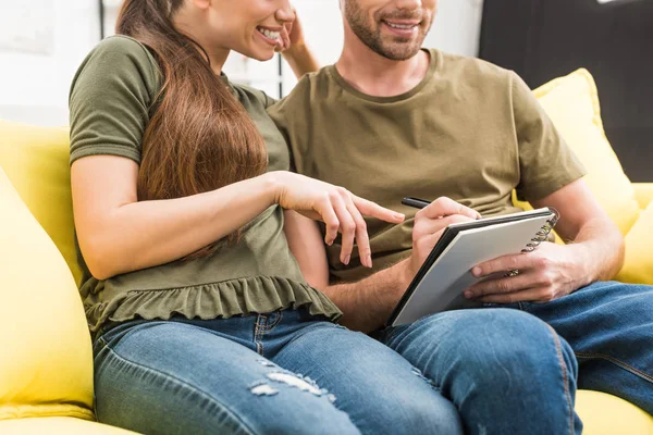 Cropped shot of couple writing in notebook together at home — Stock Photo