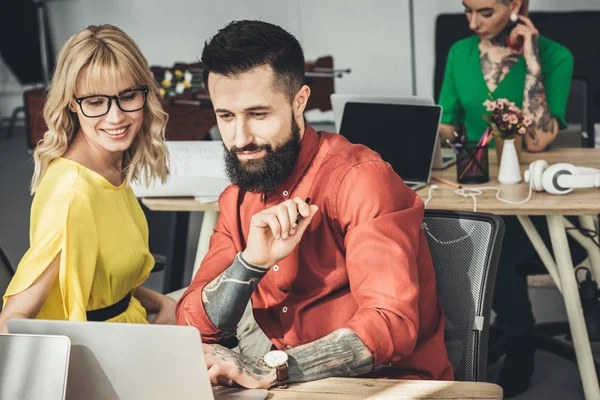 Selective focus of designer and colleagues working behind in office — Stock Photo