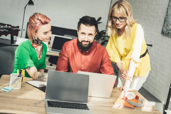 Group of young creative workers discussing new project together in office — Stock Photo