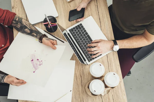 Vista aérea del diseñador y compañero de trabajo trabajando juntos en la mesa en la oficina - foto de stock